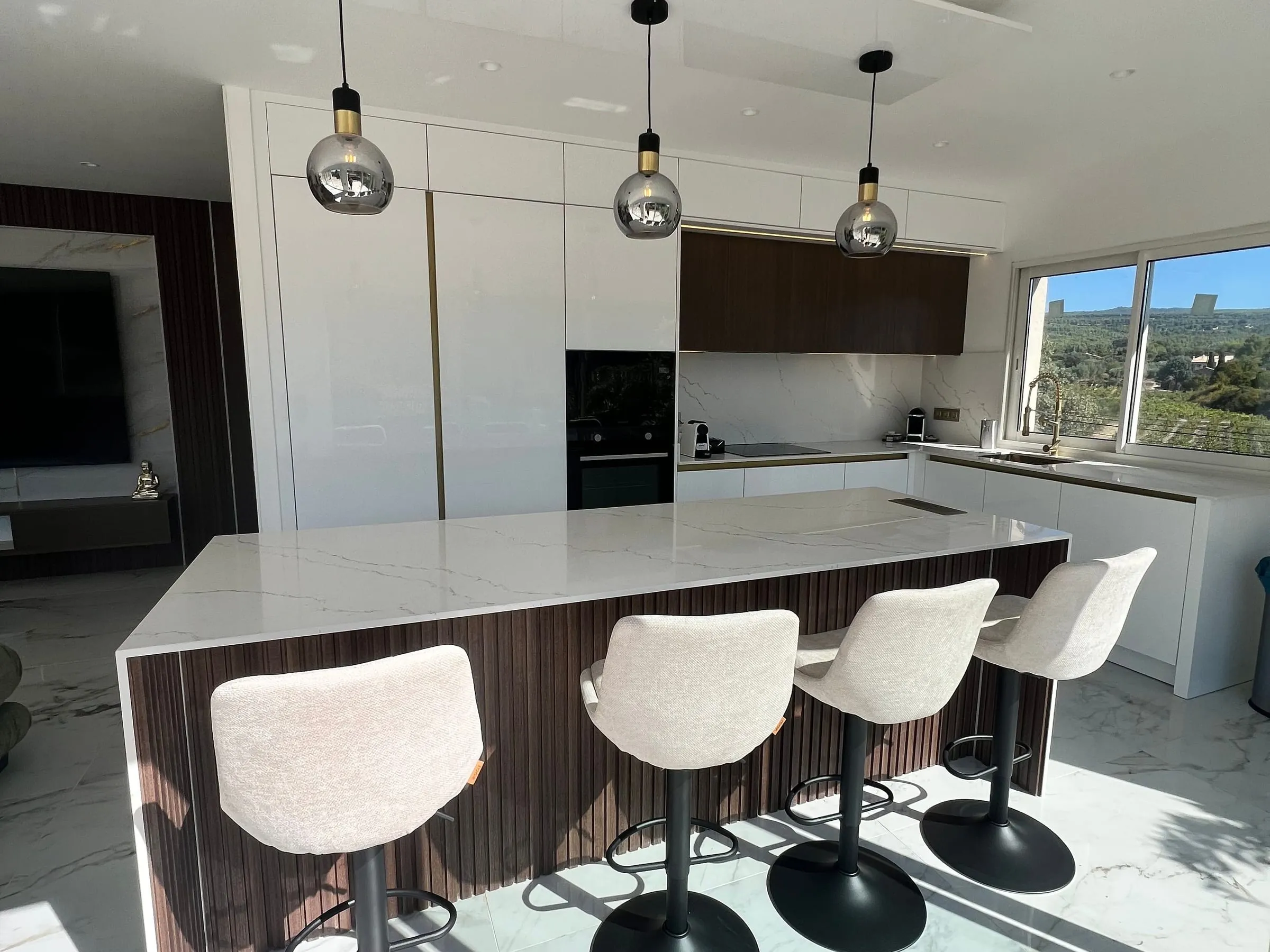 Cuisine, îlot et meuble TV dans une villa face aux vignes